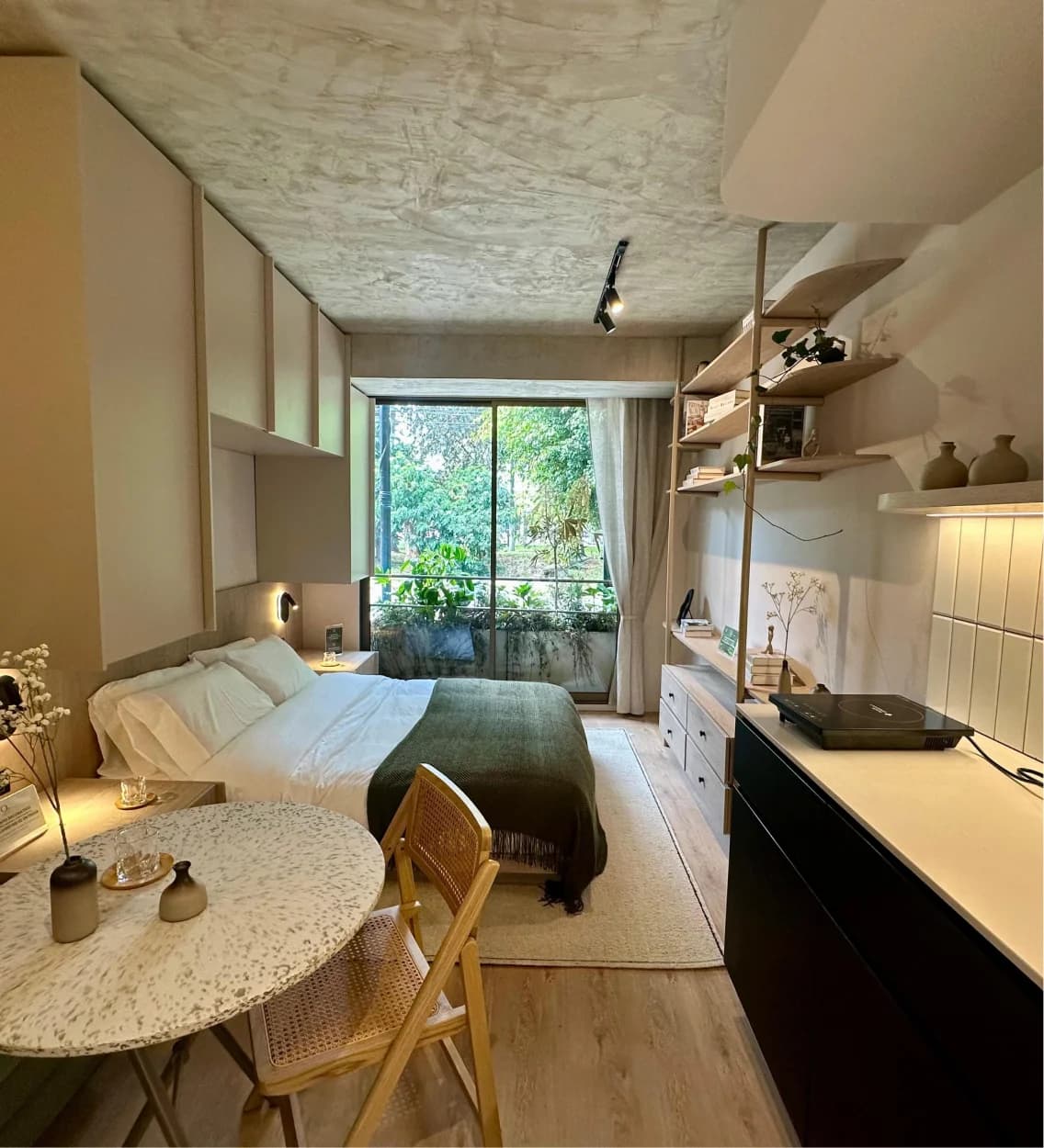 Apartaestudio con cama, mesa y balcón con jardín